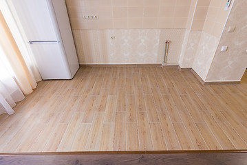 Image showing Zoning floor in the interior, ceramic kitchen tiles bordered with laminate flooring in the living room