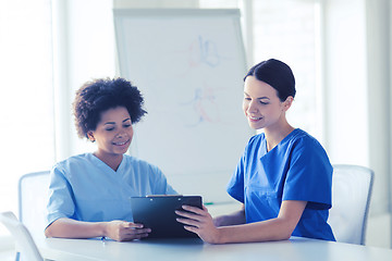 Image showing happy doctors with tablet pc meeting at hospital