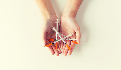 Image showing close up of woman hands holding syringes