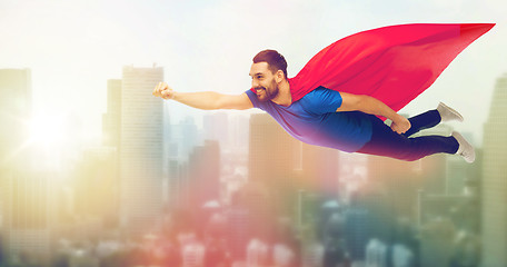 Image showing happy man in red superhero cape flying on air