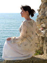 Image showing Lonely Young Woman on Stone Looking to Sea