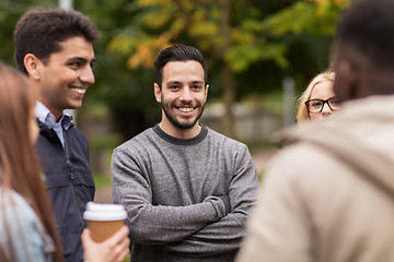 Image showing happy friends walking along autumn park