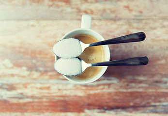 Image showing close up of white sugar on teaspoon and coffee cup