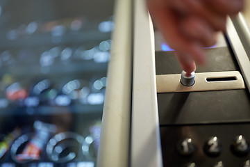 Image showing hand pushing button on vending machine