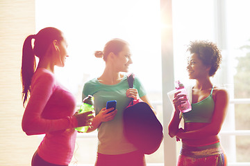 Image showing happy women with bottles of water in gym