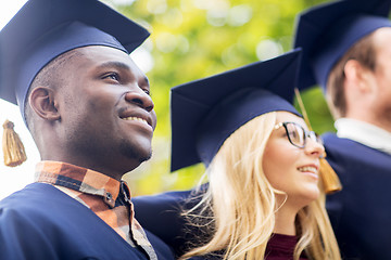 Image showing happy students or bachelors in mortar boards