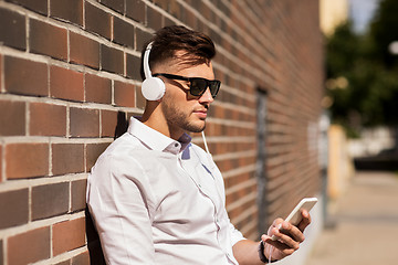 Image showing man with headphones and smartphone listening music