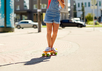 Image showing teenage girl riding skateboard on city street