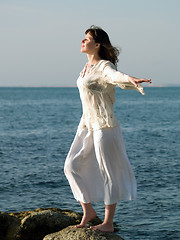 Image showing Young barefoot Lady Stays on Stone arms outstretched