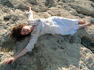 Image showing Young barefoot lady on stone beach