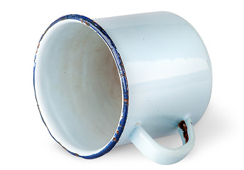 Image showing Old worn enameled mug lying