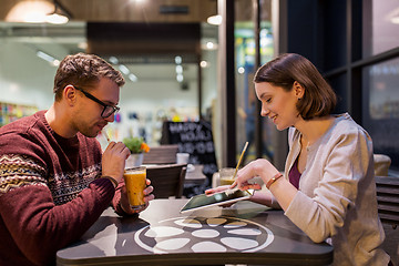 Image showing happy couple with tablet pc and smoothie at cafe