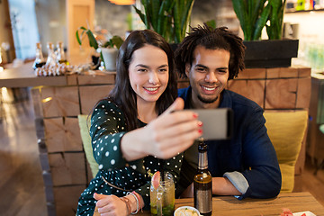 Image showing happy couple taking selfie at cafe or bar