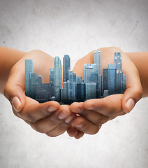 Image showing hands holding city over gray concrete background