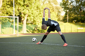 Image showing soccer player stretching leg on field football