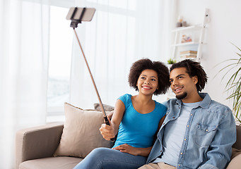 Image showing happy couple with smartphone taking selfie at home