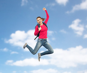 Image showing happy woman or student with backpack jumping