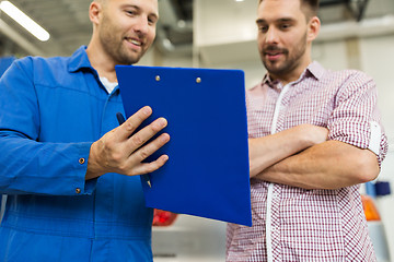 Image showing auto mechanic with clipboard and man at car shop