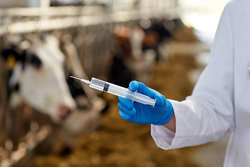 Image showing veterinarian hand with vaccine in syringe on farm