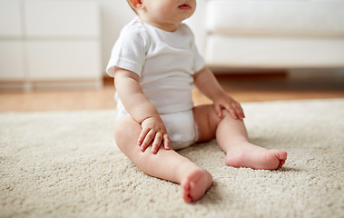 Image showing happy baby boy or girl sitting on floor at home