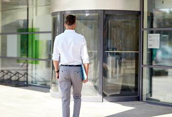 Image showing young man with folder on city street