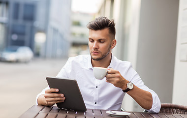 Image showing man with tablet pc and coffee at city cafe