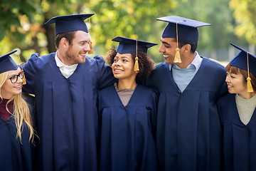 Image showing happy students or bachelors in mortar boards