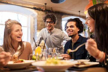 Image showing happy friends eating and drinking at restaurant