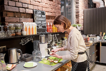 Image showing happy woman or barmaid cooking at vegan cafe