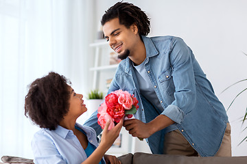 Image showing happy couple with bunch of flowers at home