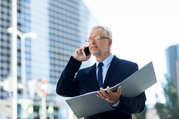 Image showing senior businessman calling on smartphone in city