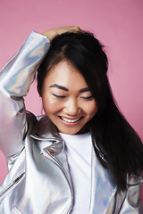 Image showing young pretty smiling asian korean girl wearing modern fashion clothers on pink background, lifestyle people concept