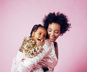 Image showing young pretty african-american mother with little cute daughter hugging, happy smiling on pink background, lifestyle modern people concept 