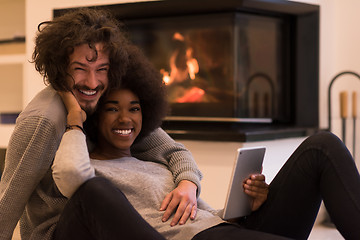 Image showing multiethnic couple used tablet computer on the floor