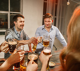 Image showing Group of friends enjoying evening drinks with beer