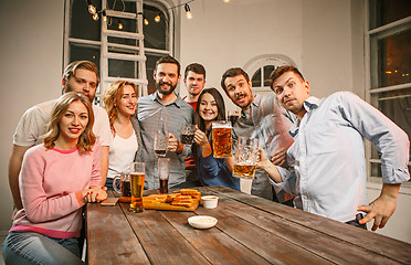 Image showing Group of friends enjoying evening drinks with beer