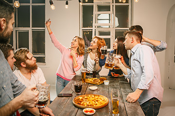 Image showing Group of friends enjoying evening drinks with beer