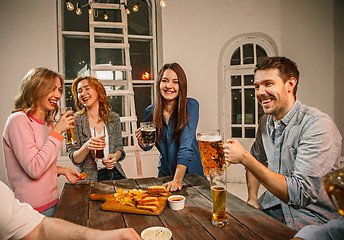 Image showing Group of friends enjoying evening drinks with beer