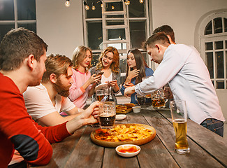 Image showing Group of friends enjoying evening drinks with beer