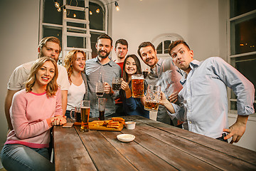 Image showing Group of friends enjoying evening drinks with beer