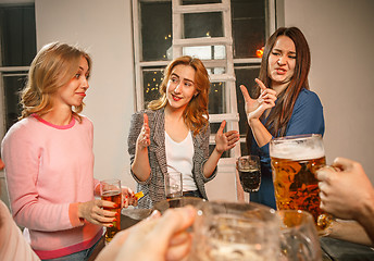 Image showing Group of friends enjoying evening drinks with beer