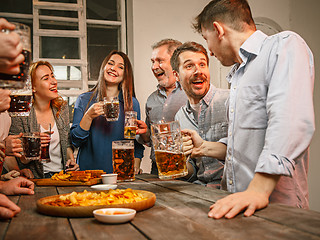 Image showing Group of friends enjoying evening drinks with beer