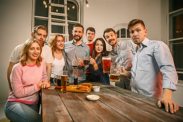 Image showing Group of friends enjoying evening drinks with beer