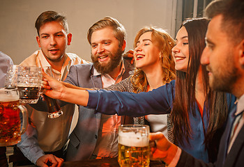 Image showing Group of friends enjoying evening drinks with beer