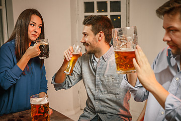 Image showing Group of friends enjoying evening drinks with beer