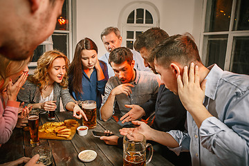 Image showing Group of friends enjoying evening drinks with beer