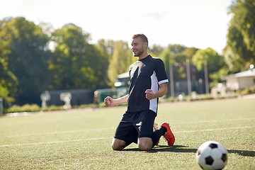 Image showing happy soccer player with ball on football field