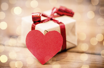 Image showing close up of gift box and heart shaped note on wood