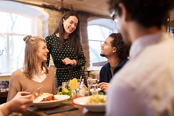 Image showing happy friends eating and drinking at restaurant