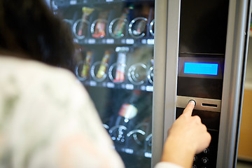 Image showing woman pushing button on vending machine